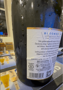 A close up view of a bottle of Ridgeview Bloomsbury English sparkling wine with water droplets proving it is chilled and featuring the official Certified B Corporation logo on the label.