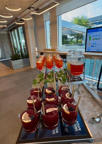 A tray of B Corp bramble mocktails garnished with blackberries and lemon on the event bar