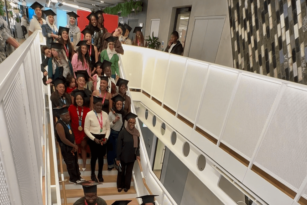 The Outrunners Academy graduation group celebrating together on the stairway at Nike's London head office
