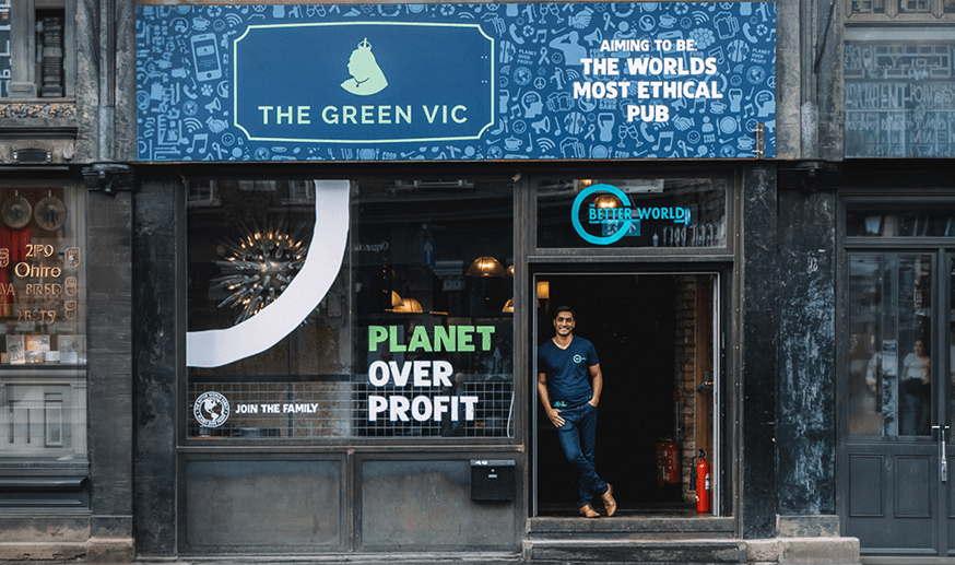 The Green Vic shopfront in Shoreditch — its awning reading 'aiming to be the world's most ethical pub' and Planet Over Profit painted across the window
