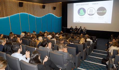 Our founder Randy Rampersad sitting on a panel on a large stage speaking to a packed audience of corporate industry leaders about sustainability strategies at The