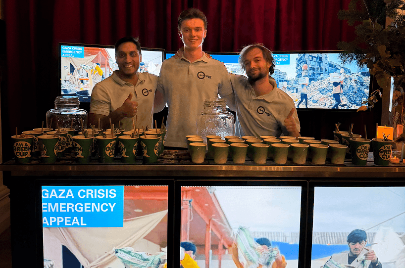 Three professional bartenders smiling behind a high tech digital screen bar providing exceptional service for a charity fundraiser event