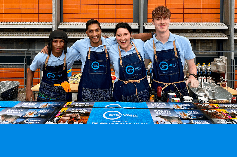 Four professional team members smiling together behind a mobile bar setup delivering polite and hardworking hospitality service for a corporate launch event